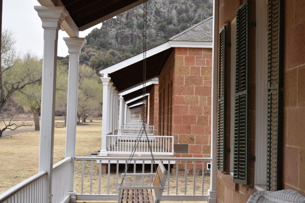 The long covered porch of the restored officers' quarters at Fort Davis National Historic Site, looking down the row toward the parade ground