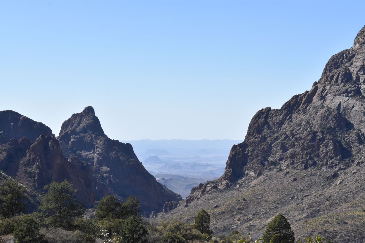 Rocky peaks framing the view down the Window Trail in the Chisos Basin, Big Bend National Park, with the desert hazy beyond
