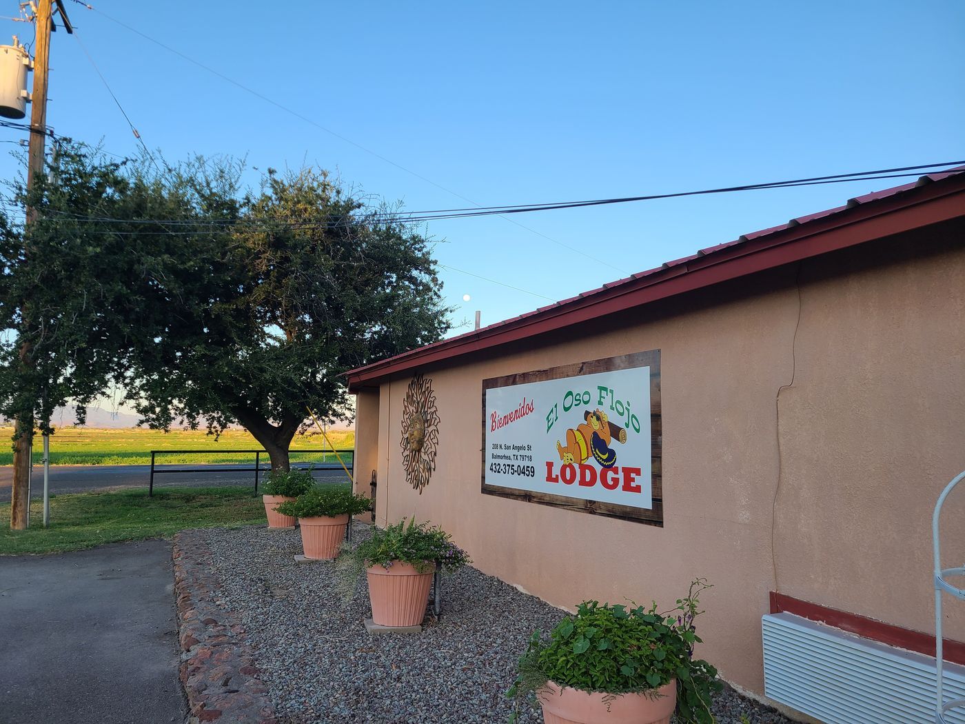 The painted sign and low stucco frontage of El Oso Flojo Lodge in Balmorhea, Texa